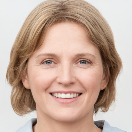 Joyful white young-adult female with medium  brown hair and blue eyes