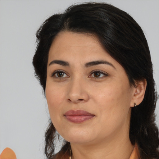 Joyful latino adult female with medium  brown hair and brown eyes