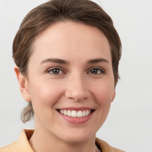 Joyful white young-adult female with short  brown hair and grey eyes