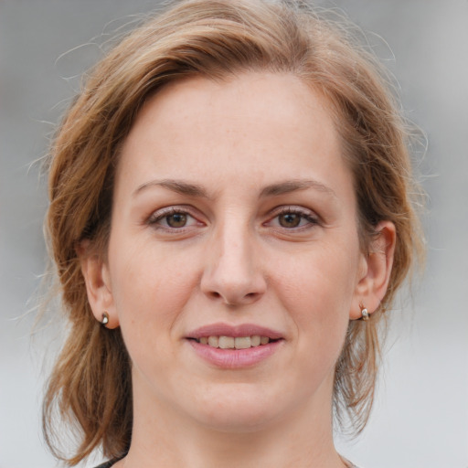 Joyful white young-adult female with medium  brown hair and blue eyes