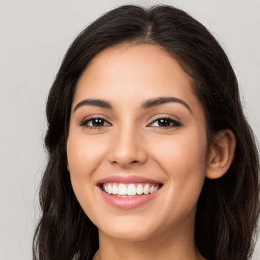 Joyful latino young-adult female with long  brown hair and brown eyes