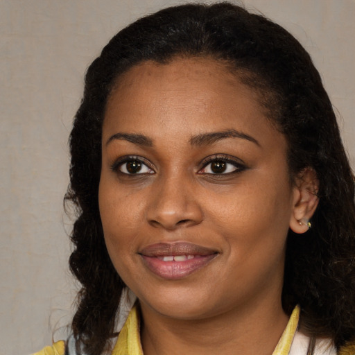 Joyful black young-adult female with long  brown hair and brown eyes