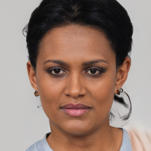 Joyful black young-adult female with short  black hair and brown eyes