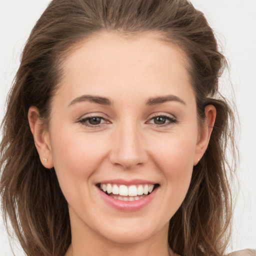 Joyful white young-adult female with long  brown hair and grey eyes