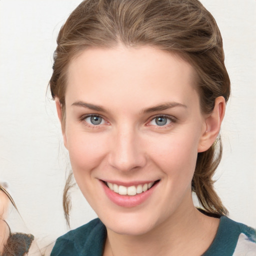 Joyful white young-adult female with medium  brown hair and blue eyes