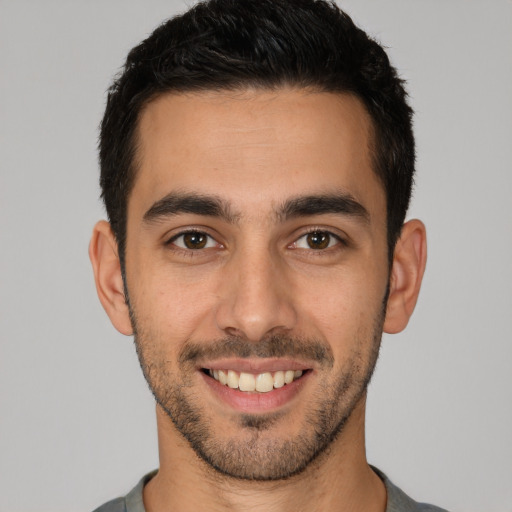 Joyful white young-adult male with short  black hair and brown eyes