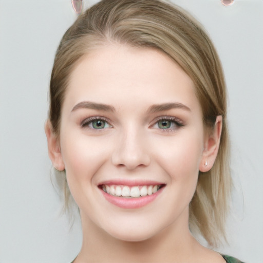 Joyful white young-adult female with medium  brown hair and green eyes