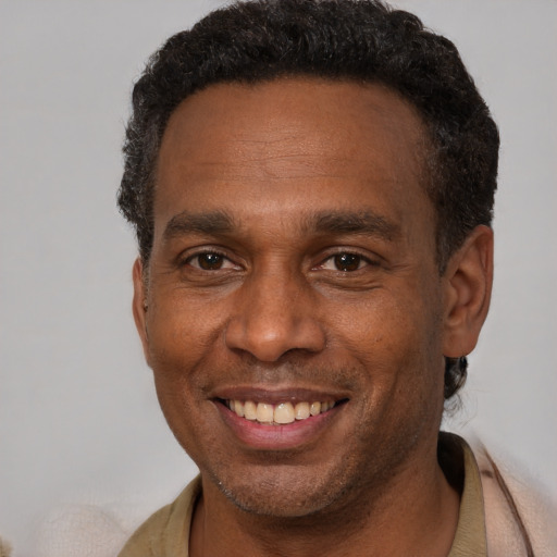 Joyful black adult male with short  brown hair and brown eyes