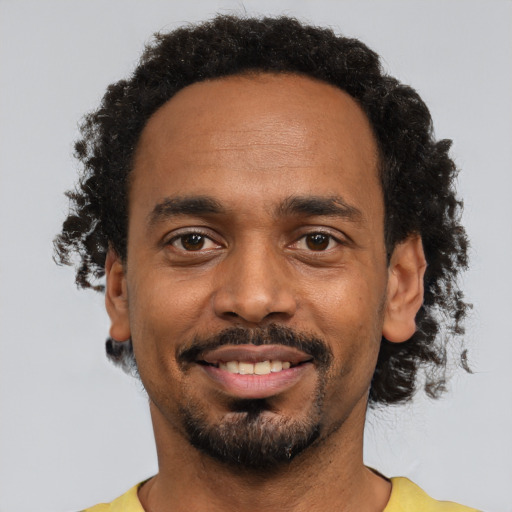 Joyful black young-adult male with short  black hair and brown eyes