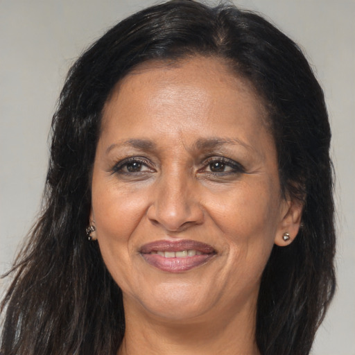 Joyful black adult female with long  brown hair and brown eyes
