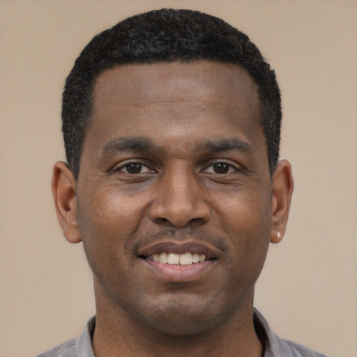Joyful black young-adult male with short  black hair and brown eyes