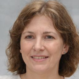 Joyful white adult female with medium  brown hair and grey eyes