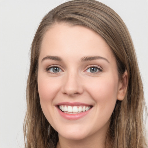 Joyful white young-adult female with long  brown hair and grey eyes