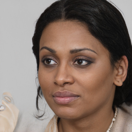 Joyful black young-adult female with medium  black hair and brown eyes