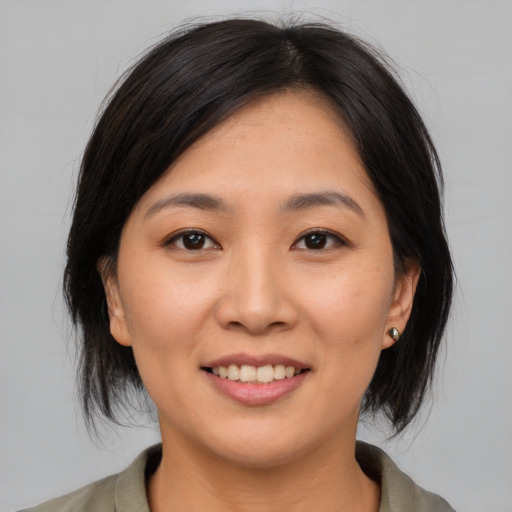 Joyful asian young-adult female with medium  brown hair and brown eyes
