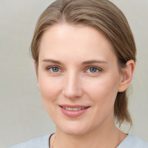 Joyful white young-adult female with medium  brown hair and blue eyes