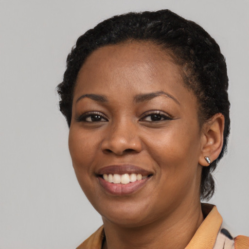 Joyful black young-adult female with short  black hair and brown eyes
