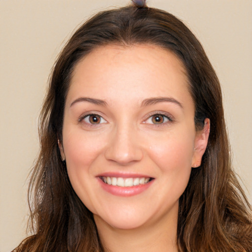 Joyful white young-adult female with long  brown hair and brown eyes