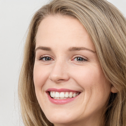 Joyful white young-adult female with long  brown hair and blue eyes