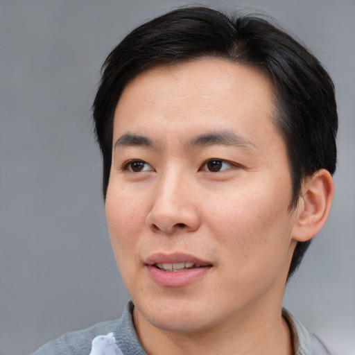 Joyful asian young-adult male with short  brown hair and brown eyes