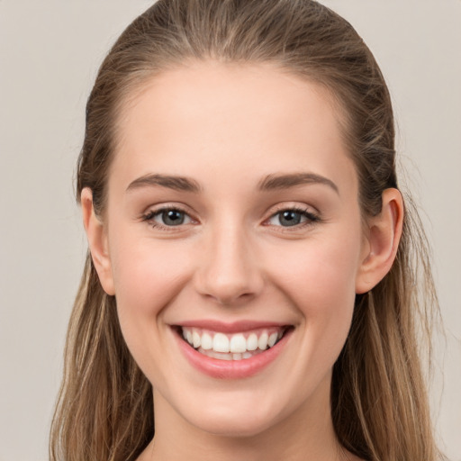 Joyful white young-adult female with long  brown hair and grey eyes