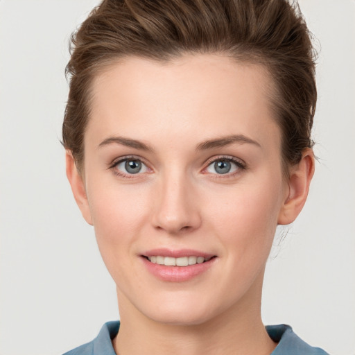 Joyful white young-adult female with short  brown hair and grey eyes