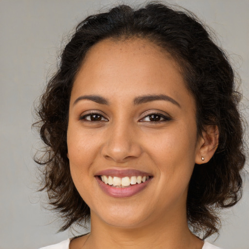 Joyful latino young-adult female with medium  brown hair and brown eyes