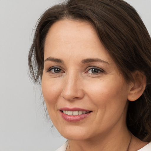 Joyful white adult female with medium  brown hair and brown eyes