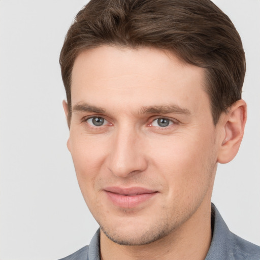 Joyful white young-adult male with short  brown hair and grey eyes