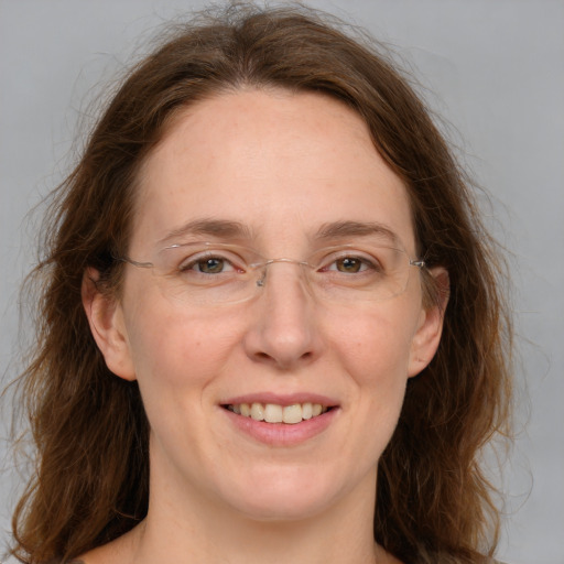 Joyful white adult female with long  brown hair and green eyes