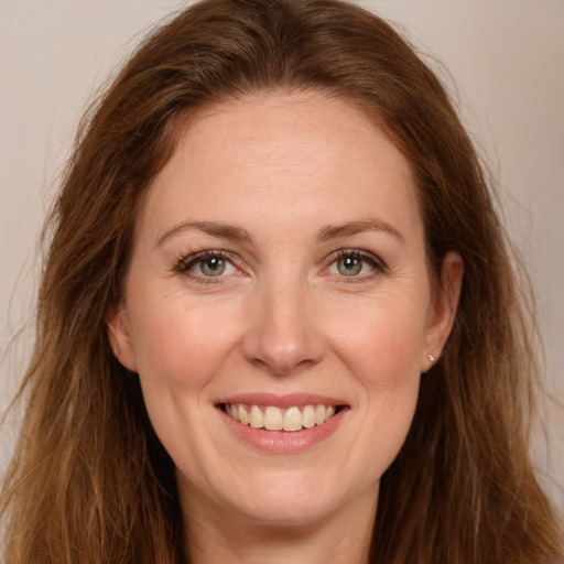 Joyful white young-adult female with long  brown hair and green eyes