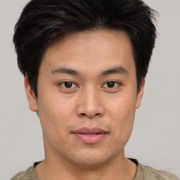 Joyful asian young-adult male with short  brown hair and brown eyes