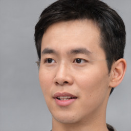 Joyful asian young-adult male with short  brown hair and brown eyes