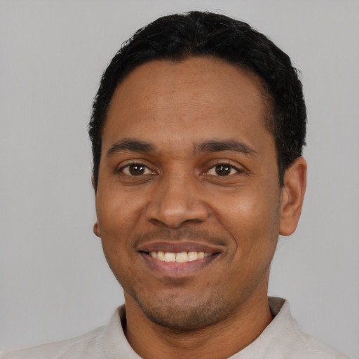 Joyful latino young-adult male with short  black hair and brown eyes