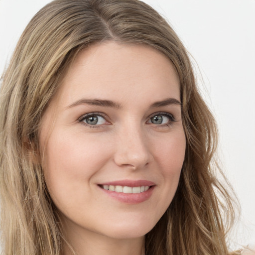 Joyful white young-adult female with long  brown hair and blue eyes