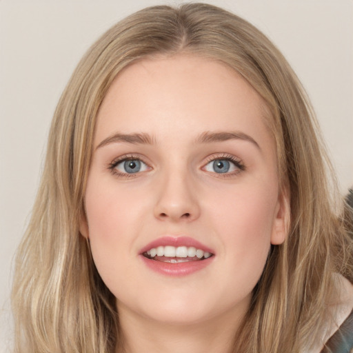 Joyful white young-adult female with long  brown hair and blue eyes