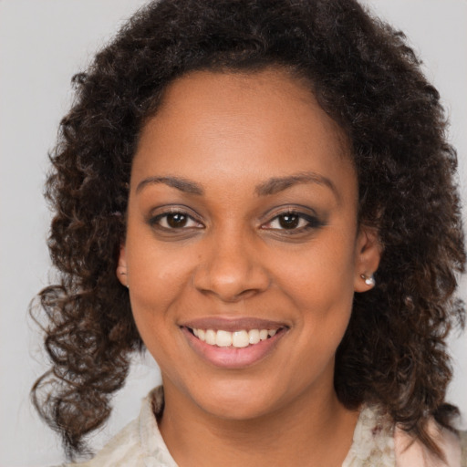 Joyful black young-adult female with medium  brown hair and brown eyes