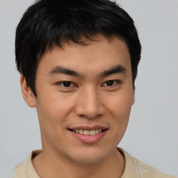 Joyful asian young-adult male with short  brown hair and brown eyes