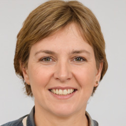 Joyful white adult female with medium  brown hair and grey eyes