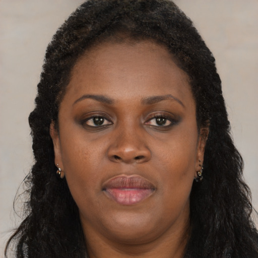 Joyful black young-adult female with long  brown hair and brown eyes