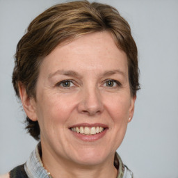 Joyful white adult female with medium  brown hair and grey eyes