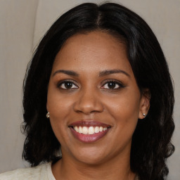 Joyful black young-adult female with medium  brown hair and brown eyes