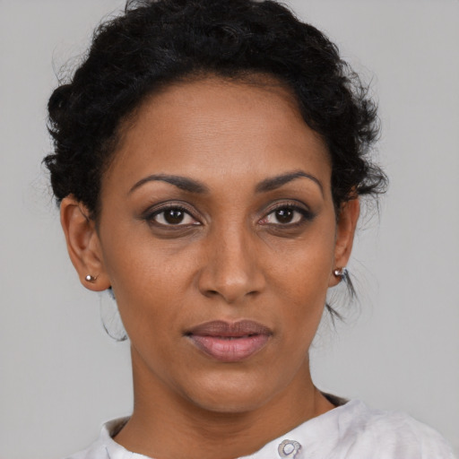 Joyful black young-adult female with medium  brown hair and brown eyes