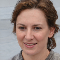 Joyful white adult female with medium  brown hair and blue eyes