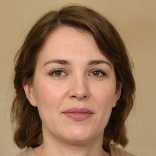 Joyful white adult female with medium  brown hair and green eyes