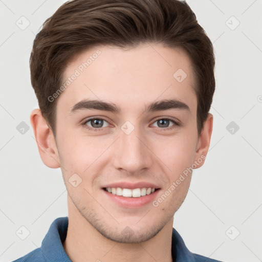 Joyful white young-adult male with short  brown hair and grey eyes