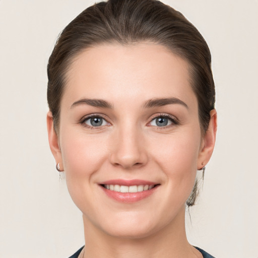 Joyful white young-adult female with medium  brown hair and grey eyes