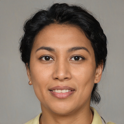 Joyful latino young-adult female with medium  brown hair and brown eyes