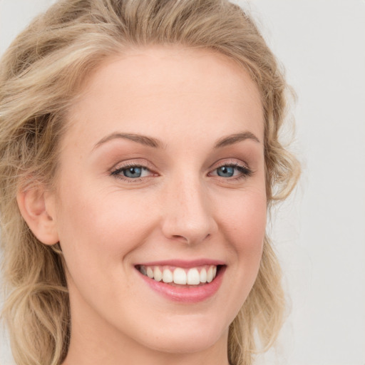 Joyful white young-adult female with long  brown hair and blue eyes