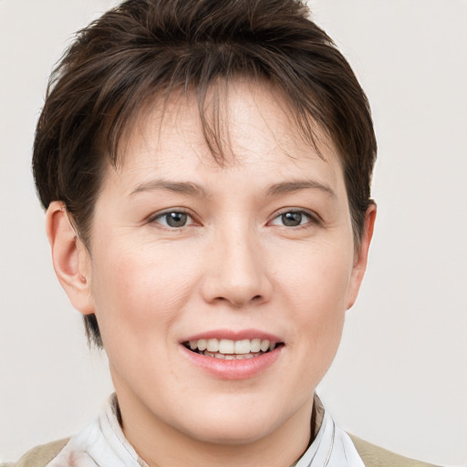 Joyful white young-adult female with short  brown hair and grey eyes